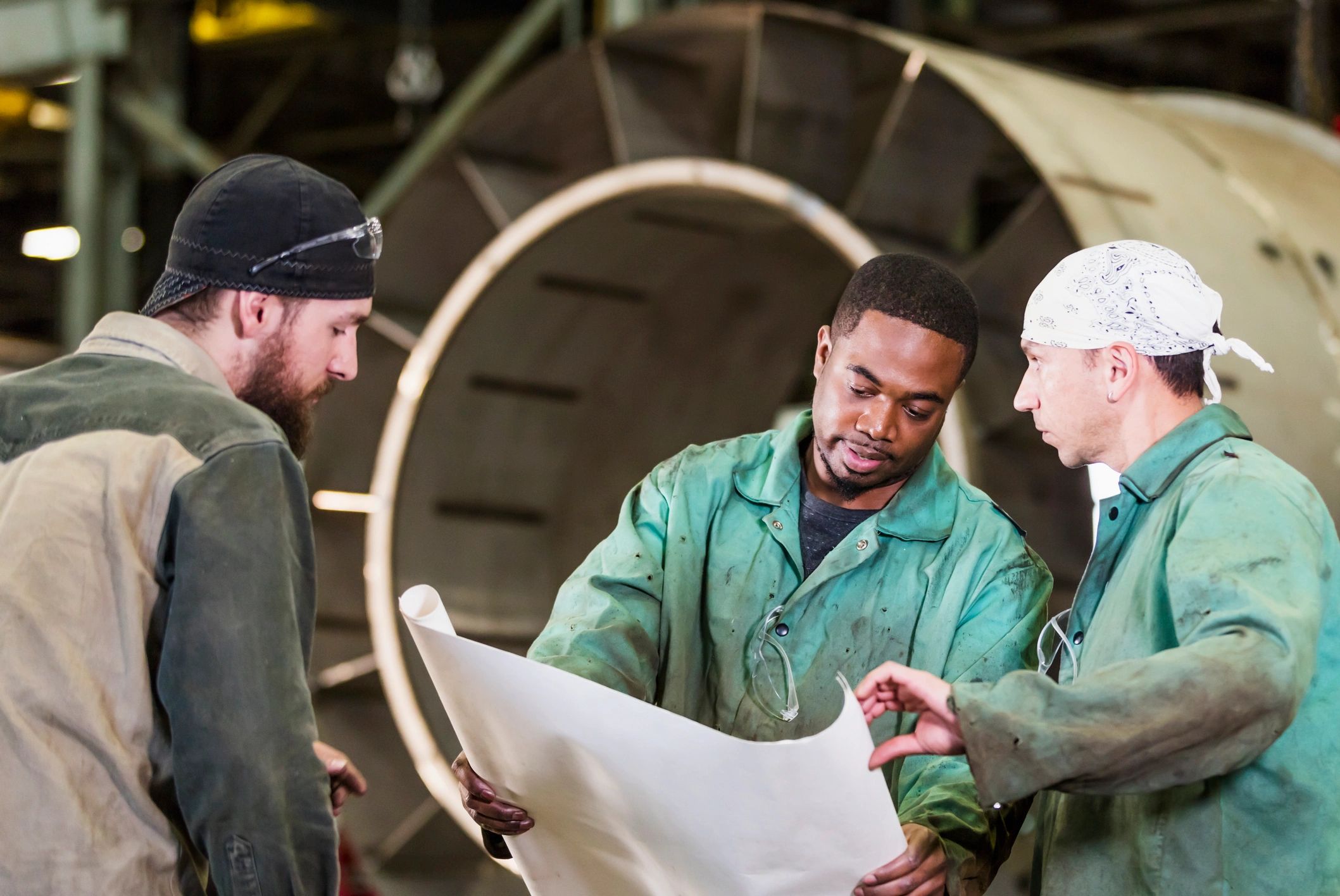 Engineers reviewing technical plans in a fabrication shop